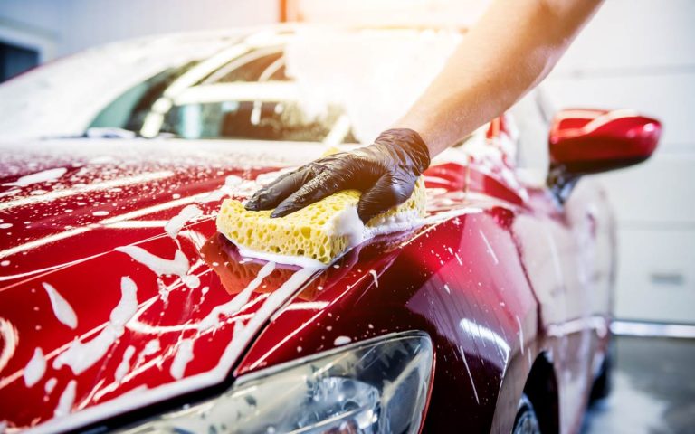 worker-washing-red-car-with-sponge-car-wash